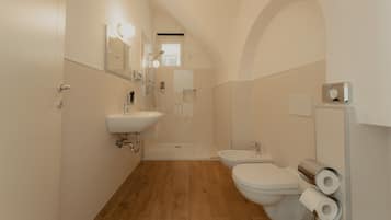 Un bagno moderno con doccia, WC e lavandino.