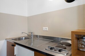 A compact kitchen with a stainless steel sink, a built-in stove, and a small countertop.