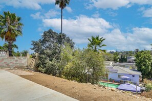 A residential area with houses, a clear sky, and palm trees.