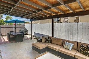 An outdoor patio area with a covered seating arrangement, a table, and a grill. - 5 Mi to SDSU & Trails! Stylish Apartment w/ Patio (La Mesa)