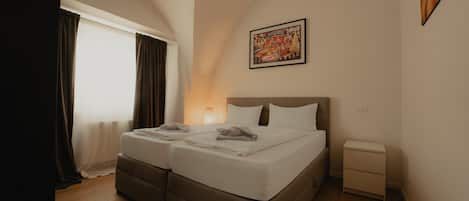 A double bed with a headboard, a bedside table, and a wall-mounted picture.