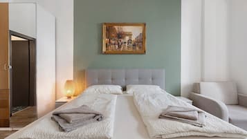 Una habitació d'hotel amb un llit, un quadre, una tauleta de nit i una làmpada.