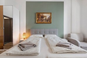 Una habitación de hotel con cama, un cuadro, una mesita de noche y una lámpara.