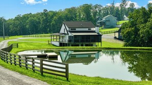 A lakeside property with a house, a dock, and a fenced area. - The Lily Pad - Nolin Lake Retreat (Clarkson)