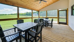 A covered outdoor area with wooden flooring, tables, chairs, and a ceiling fan. - The Lily Pad - Nolin Lake Retreat (Clarkson)