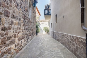 Un vialetto in pietra che conduce a un edificio con tetto in tegole e un balcone.