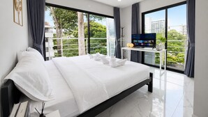 Een moderne hotelkamer met een groot bed, een flatscreen-tv en een balkon met uitzicht over de stad.