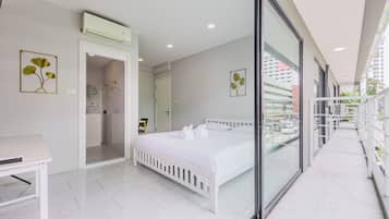 Una habitación de hotel moderna con cama, escritorio y baño.