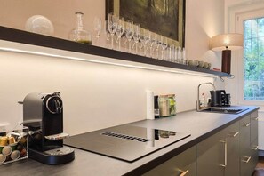 Eine moderne Küche mit einer Kaffeemaschine, einem Weinkühlschrank und einem Kaffeekocher auf der Arbeitsfläche.