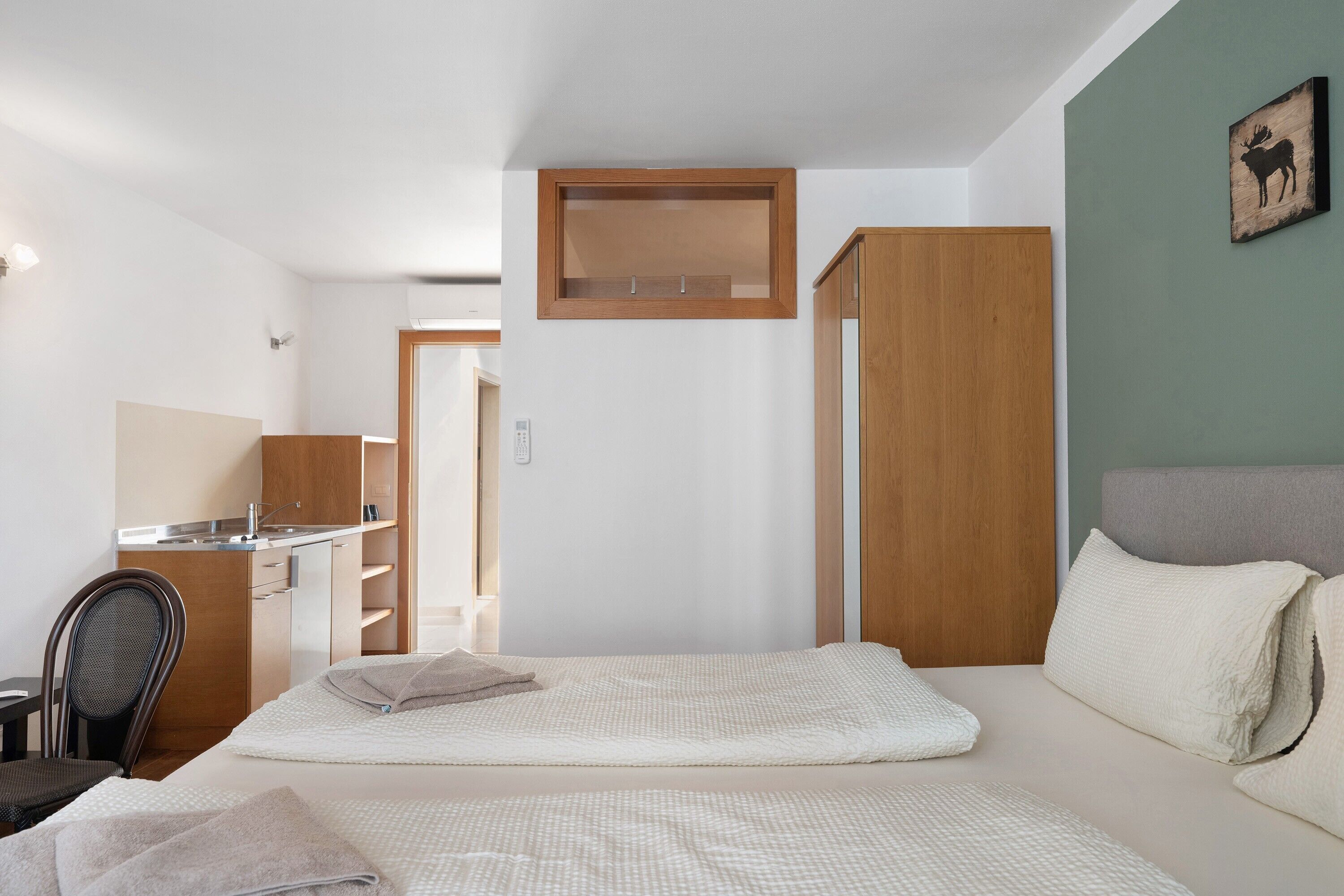 Una habitación de hotel pequeña con una cama, un escritorio y una silla.