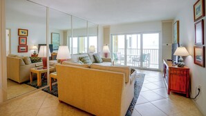 Ein Wohnzimmer mit Sofa, Sesseln, einem Couchtisch und einem Essbereich mit Stühlen.