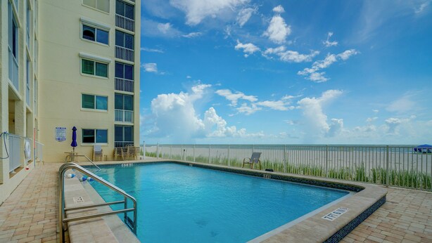 Ein Swimmingpool mit blauem Himmel und Blick auf den Strand.