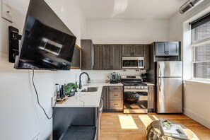 Eine moderne Küche mit integriertem Mikrowellenherd, Herd und Kühlschrank.