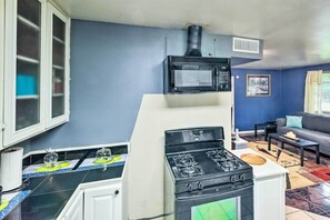 A compact kitchen with a stove, microwave, and a small window. - Family Home + Guest House! Near Fishing, Boat Ramp (West Orange)