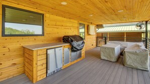Un interno in legno con angolo cottura, una finestra e una ventola.