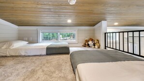A bedroom with two beds, a window, and a view of trees. - Tiny Home - Fire Pit, Grill, Deck & View! (Franklin)