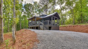 A cabin with a covered deck and a staircase leading to a second floor. - Tiny Home - Fire Pit, Grill, Deck & View! (Franklin)