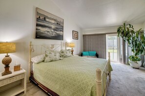 A bedroom with a bed, bedside lamps, a painting, a potted plant, and a view through the window. - Near Golf & Buzzers Baseball! Ontario Ranch Home (Ontario)
