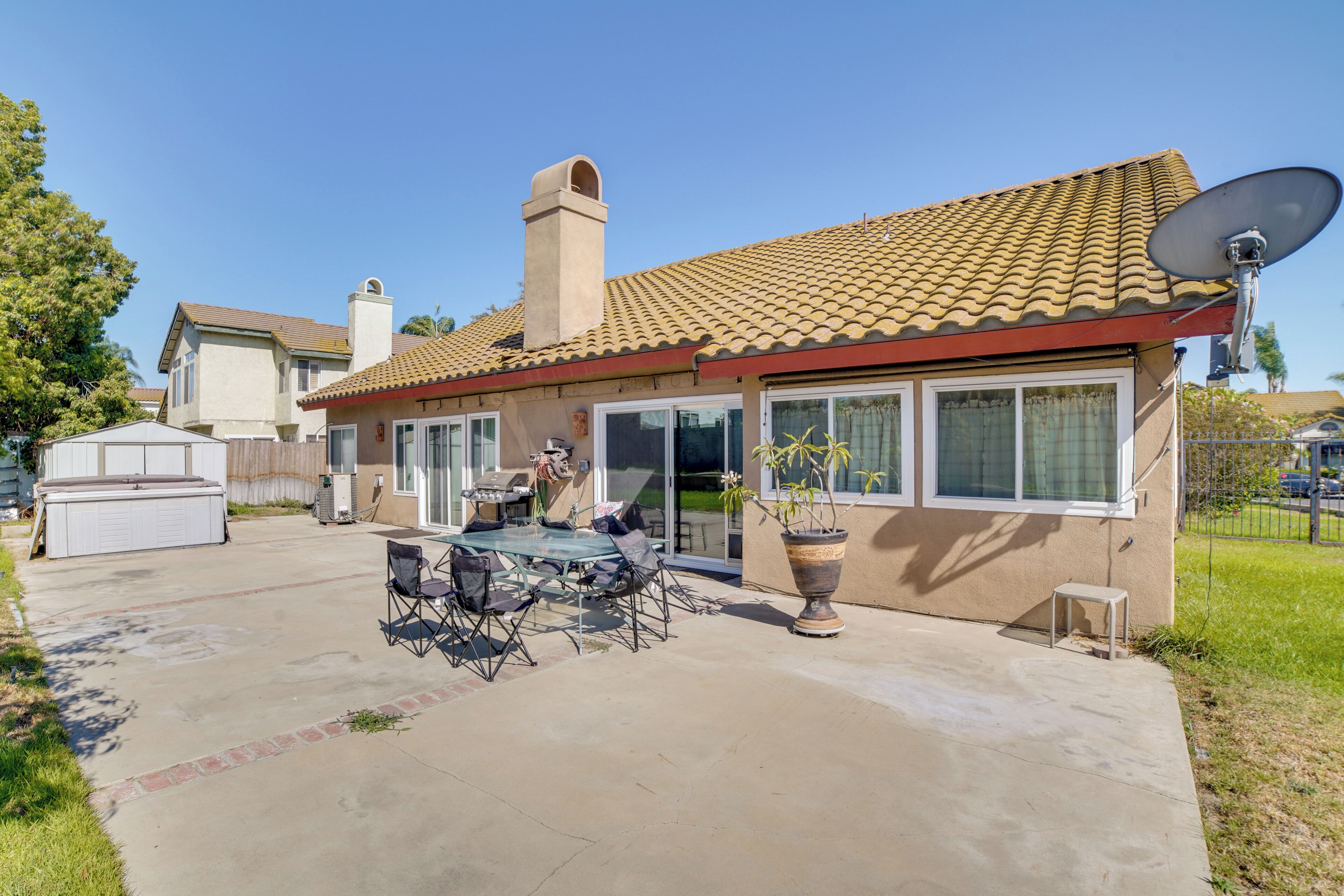 A residential house with a patio, outdoor furniture, a satellite dish, and a garage.