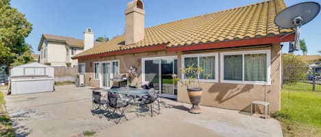 A residential house with a patio, outdoor furniture, a satellite dish, and a garage.