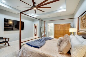 A bedroom with a bed, a ceiling fan, a TV, and a wardrobe. - Heated Pool & Lanai Cookouts! Cape Coral Getaway (Cape Coral)