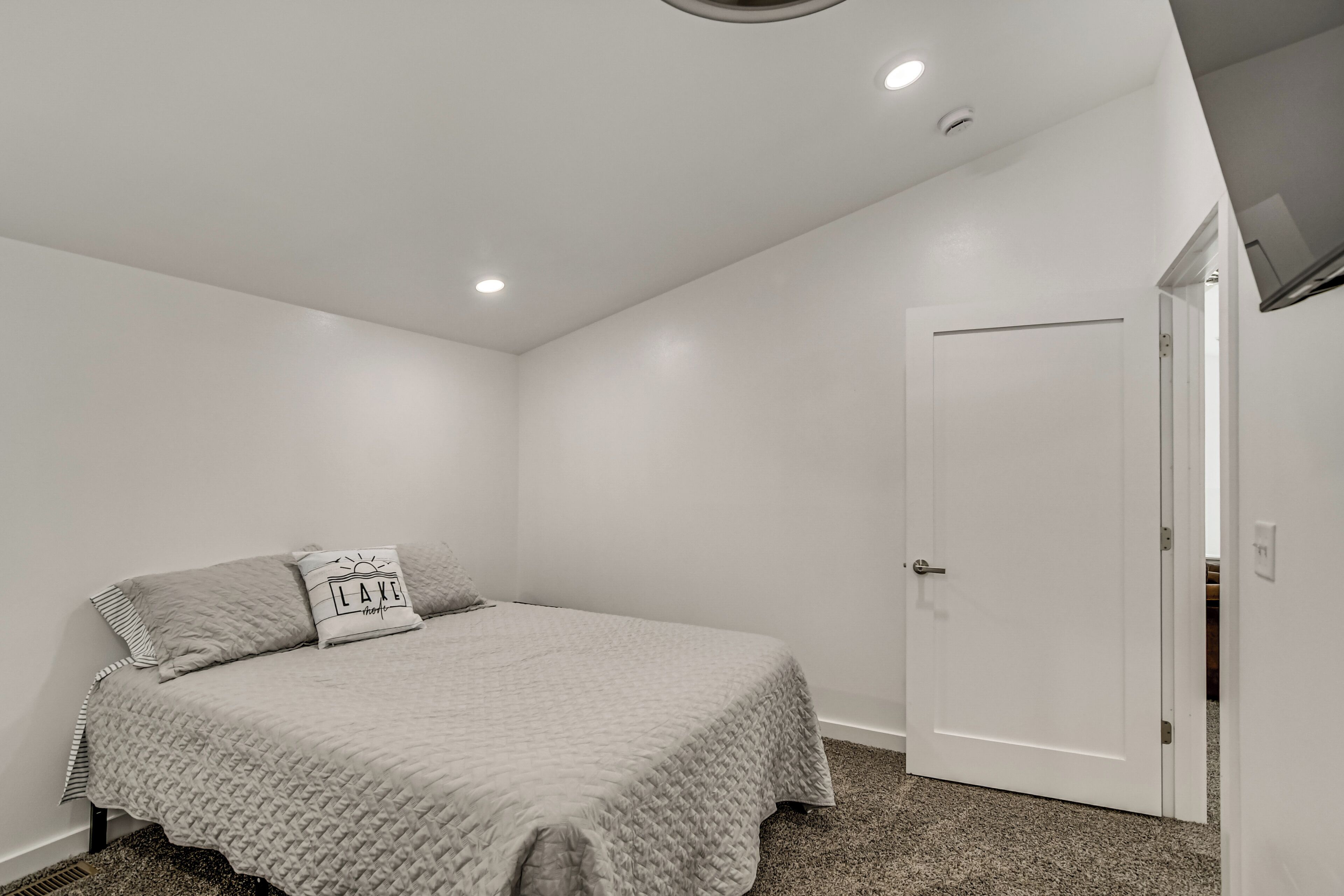 Una camera da letto con un letto, una porta e una lampada a soffitto.