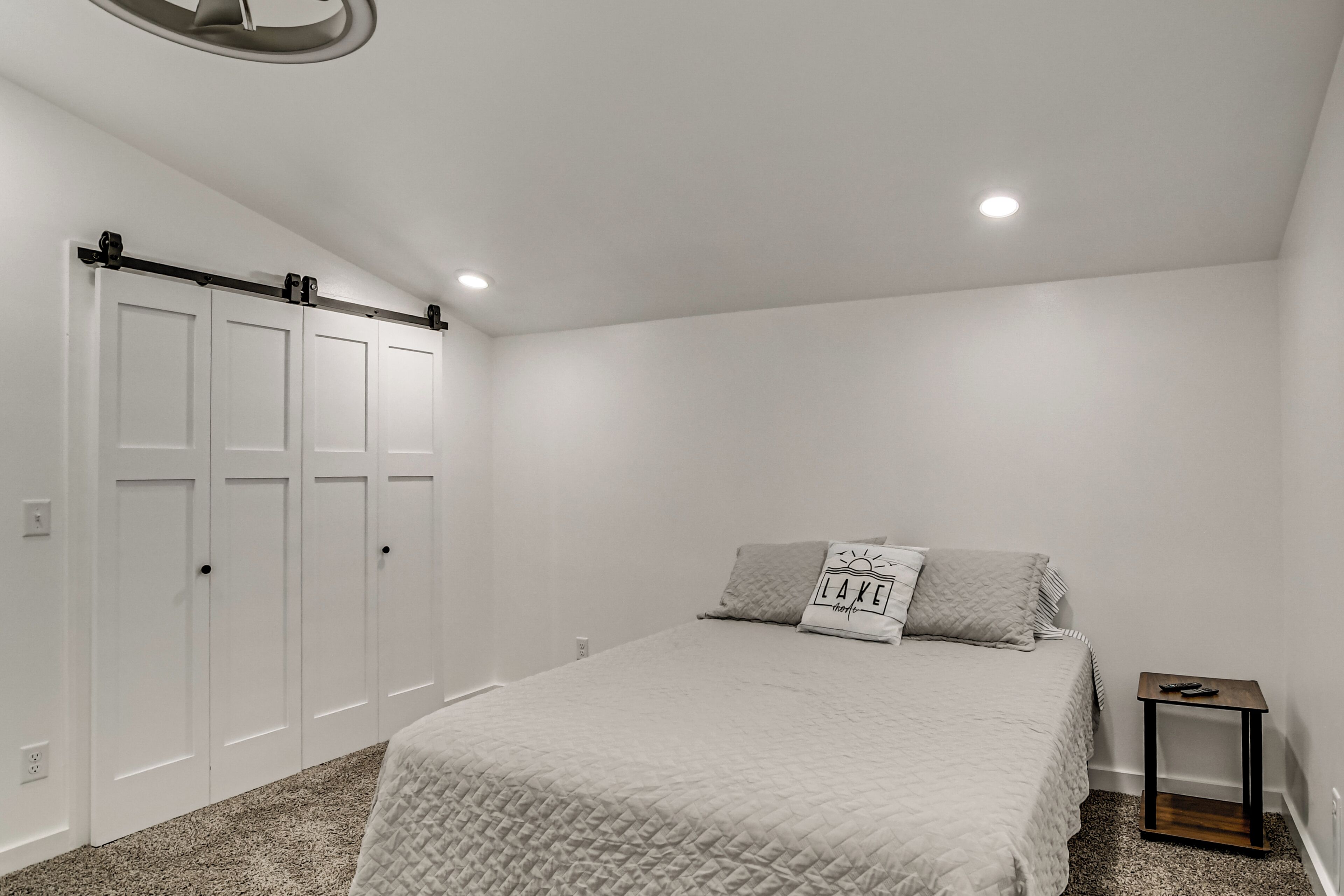Un dormitorio con cama, mesita de noche y armario.