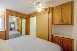 Ein Schlafzimmer mit einem Bett, einem Holzschrank und einem Deckenventilator.