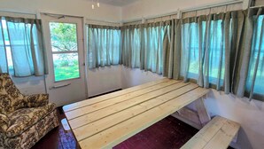 A room with a wooden bench, a patterned armchair, and a door leading outside. - Pet-Friendly Rustic Cabin Steps from Lake Chetek (Chetek)