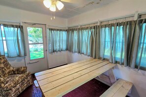 A room with a wooden bench, a patterned armchair, and a door leading outside. - Pet-Friendly Rustic Cabin Steps from Lake Chetek (Chetek)