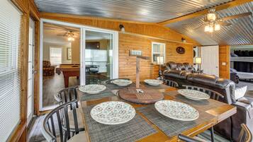 A cozy interior with a dining area, a sofa, and a bunk bed.