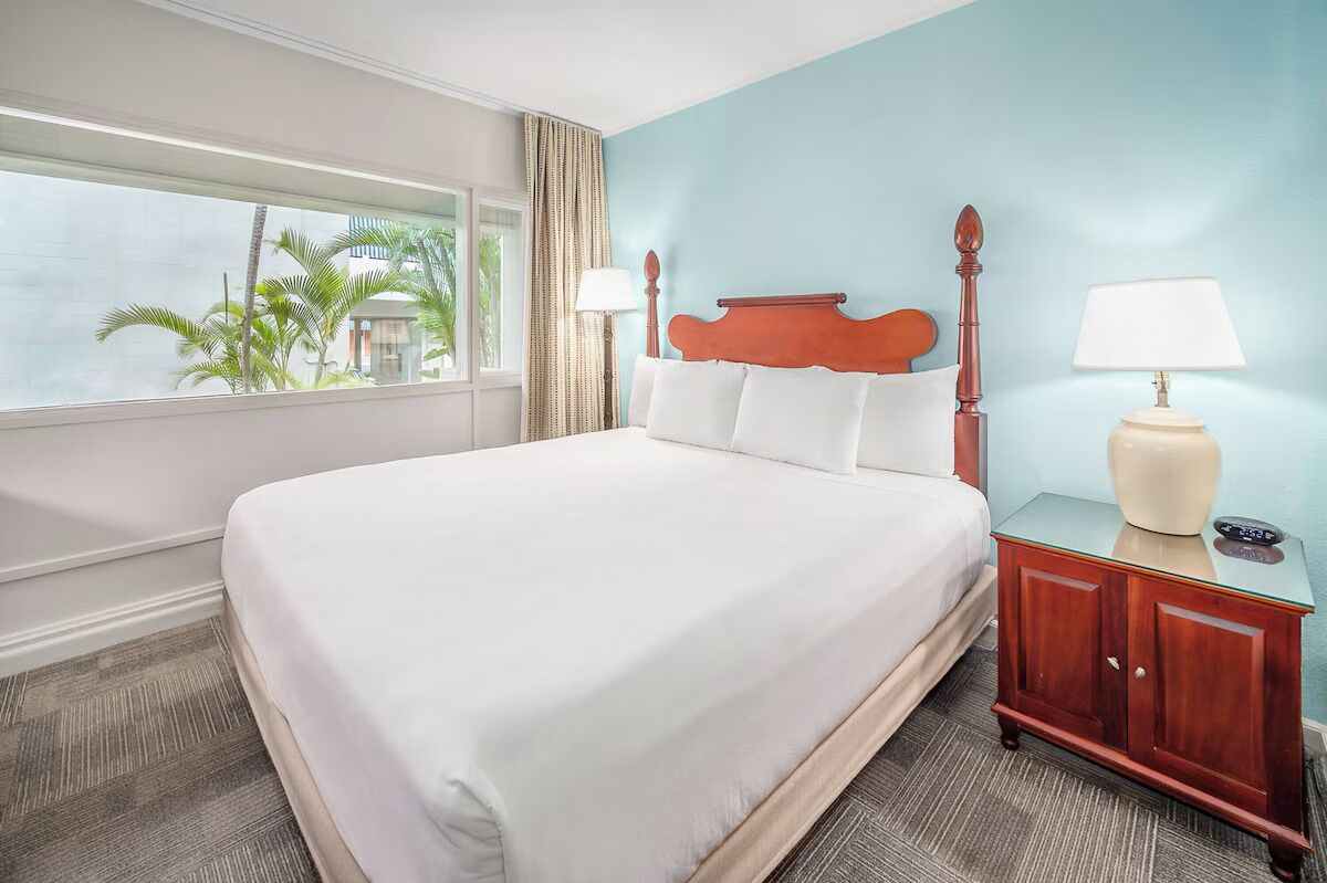 Sink into crisp king linens beside sunny tropical windows.