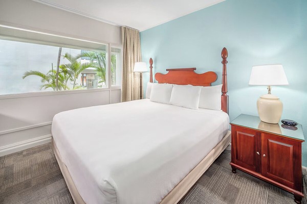 Sink into crisp king linens beside sunny tropical windows.