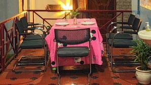 Een eetgedeelte met een tafel voor vier personen, omringd door stoelen met een gaasrug.