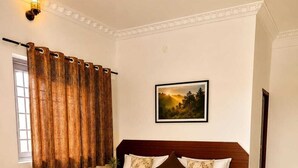 Een slaapkamer met een houten bed, een schilderij aan de muur en een raam met gordijnen.