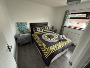 A bedroom with a bed, nightstands, a window, and a poster on the wall. - BridAj's Place is a full Semi-detached 3 Bed home with parking full of History. (Belfast)