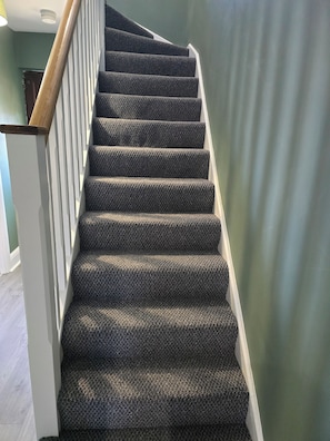A staircase with a textured carpet and wooden handrail, leading to a room with a green wall. - BridAj's Place is a full Semi-detached 3 Bed home with parking full of History. (Belfast)