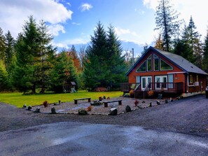 A lodge with a wooden exterior, a porch, and a stone pathway leading to the entrance. - Wonderful 3-bedroom house with AC in charming Packwood (Packwood)