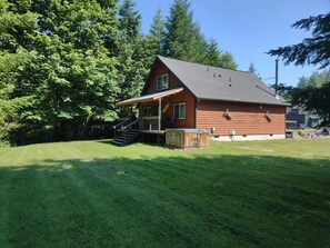 Eine Holzhütte mit Veranda, Treppe und einer kleinen Terrasse.