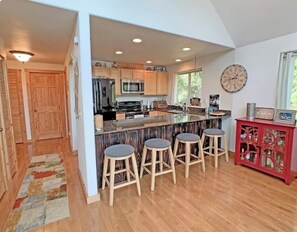 A modern kitchen with a central island, bar stools, and a red cabinet with glass doors. - Wonderful 3-bedroom house with AC in charming Packwood (Packwood)