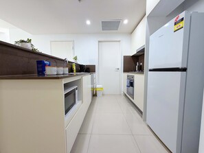 A modern kitchen with white cabinets, a stainless steel refrigerator, and a built-in oven. - Luxury 1BR Escape in Heart of Parramatta (Parramatta)