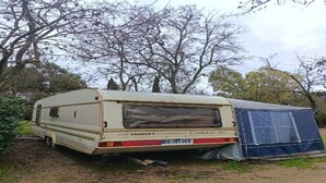A caravan parked in a wooded area with a blue tent nearby. - Large Tabbert trailer located near the sea in Hyères—secure Beldemé campground (Hyères)