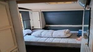 A compact bedroom with a single bed, a wardrobe, and a small bedside table. - Large Tabbert trailer located near the sea in Hyères—secure Beldemé campground (Hyères)