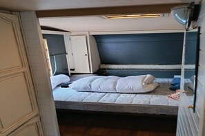 A compact bedroom with a single bed, a wardrobe, and a small bedside table. - Large Tabbert trailer located near the sea in Hyères—secure Beldemé campground (Hyères)