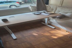 A compact living space with a foldable table, a sofa, and a window with a view of the outside. - Large Tabbert trailer located near the sea in Hyères—secure Beldemé campground (Hyères)