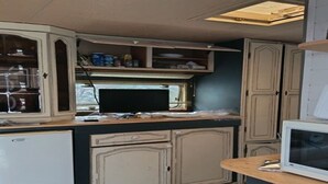 A compact kitchen with cabinetry, a microwave, and a small refrigerator. - Large Tabbert trailer located near the sea in Hyères—secure Beldemé campground (Hyères)