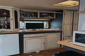 A compact kitchen with cabinetry, a microwave, and a small refrigerator. - Large Tabbert trailer located near the sea in Hyères—secure Beldemé campground (Hyères)