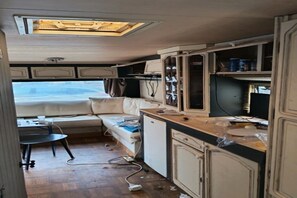 A compact kitchenette with a refrigerator, a small sink, and a countertop. - Large Tabbert trailer located near the sea in Hyères—secure Beldemé campground (Hyères)
