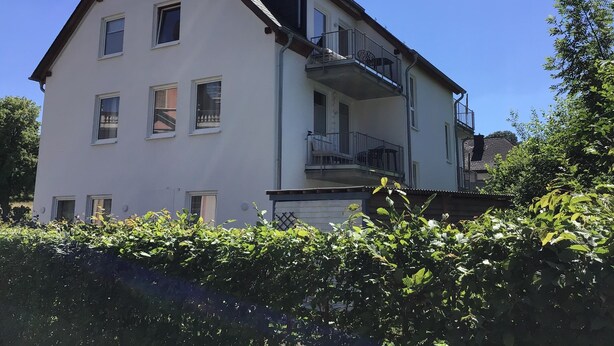 Een gebouw met twee verdiepingen, meerdere ramen en balkons.