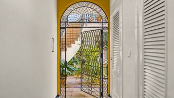 A hallway with a decorative metal gate leading to a staircase.
